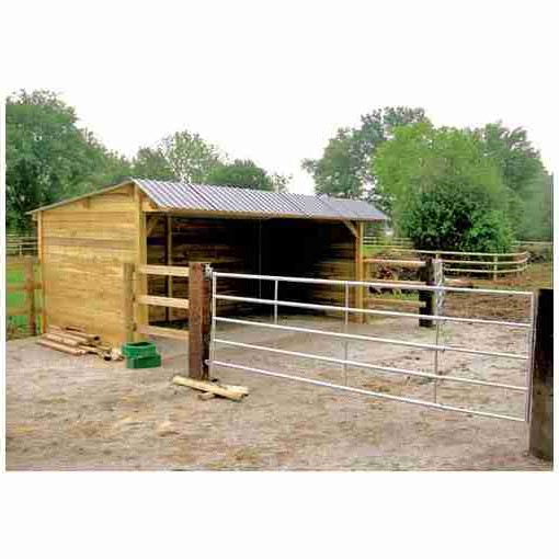 Abri pour chevaux en bois avec clins, toit double pente, collé à une clôture et une barrière.