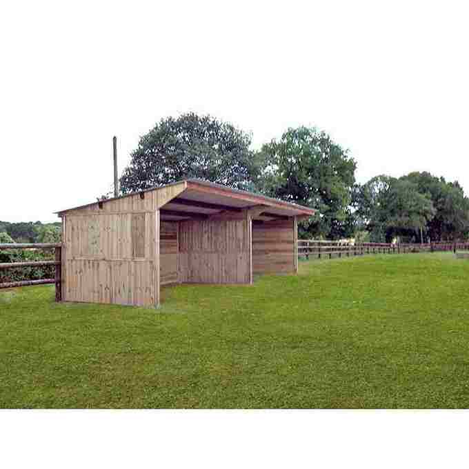 Grand abri pour chevaux avec séparation, vue de profil, avec une clôture en bois derrière.