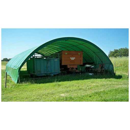 Tunnel de stockage en PVC vert, destiné au rangement d'engins et de matériaux agricoles.