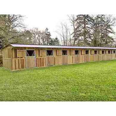 Boxes alignés à panneaux, avec grand auvent, et une forêt en arrière-plan.