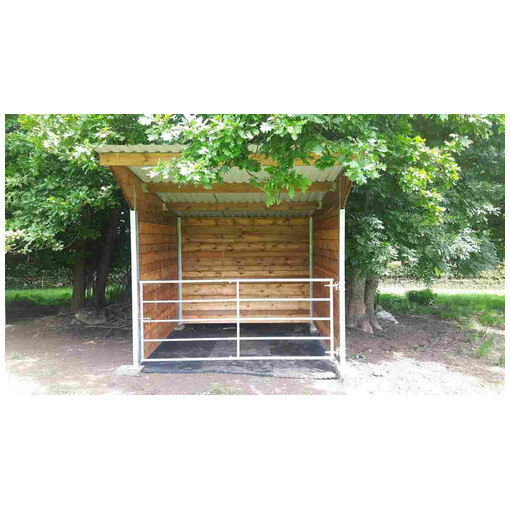 Abri pour chevaux en bois à ossature métallique, vue de près et de face, avec une barrière en acier.