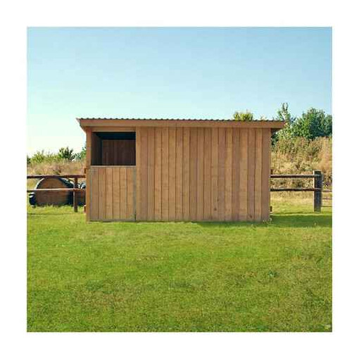 Box à bardage, vu de face, à côté d’une clôture en bois et de bottes de foin.