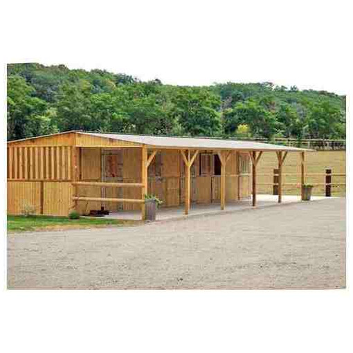 Boxes alignés à panneaux avec avancée, vus de profil, à côté d’un paddock et d’une clôture.