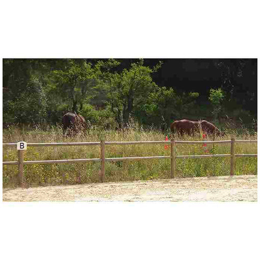 Clôture à 2 lisses en bois à l’extrémité d’une carrière, avec des chevaux en arrière-plan.