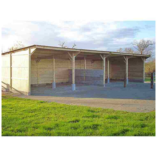 Hangar d'élevage pour chevaux en construction vu légèrement de profil.