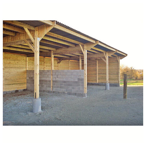 Hangar d'élevage pour chevaux en construction vu de très près sur les fondations.