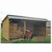 Abri pour chevaux en bois avec clins, toit double pente, servant de hangar à foin à côté d’un poney.