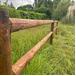 Clôture à deux lisses rondes en bois, vue en étant collé à la barrière de manière à faire apparaître les renforts.